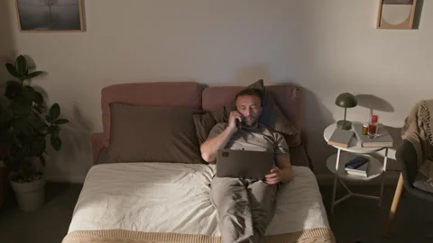 Time Lapse of Young Male Programmer Lying in Bed, Working on Laptop at Home Stock Footage 314837127