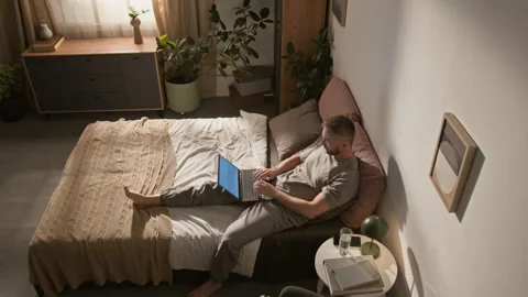 Time Lapse of Young Man Working on Laptop on Bed then Going to Sleep Stock Footage 314835816
