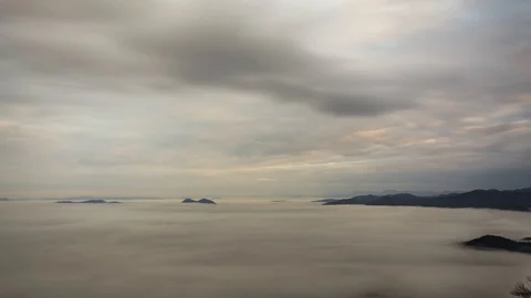Time lapse zoom in view of clouds moving above with fog bellow Stock Footage 128140869