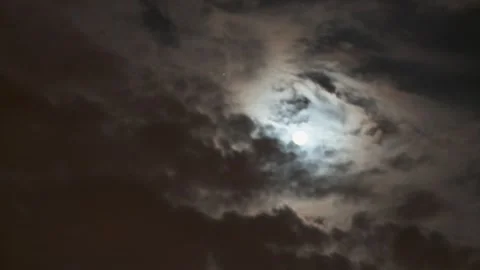 Time lapsed long shot of clouds moving over the moon Stock Footage 310385572