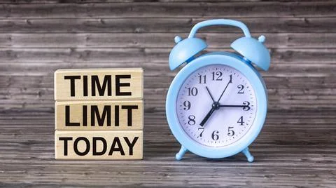 The TIME LIMIT TODAY message is written on wooden blocks, next to an alarm cl Stock Photos