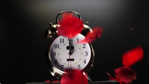 Time for Love as rose petals fall on alarm clock Valentine's Day slow motion Vidéo 208533764