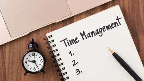 Time management concept with clock and list on notebook on wooden desk Stock Photos