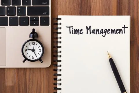 Time management concept with clock on computer, notebook and pen Stock Photos