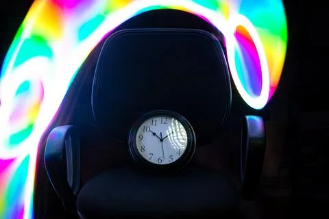 Time management concept, deadline. A clock on an office chair with multicol.. Stock Photos