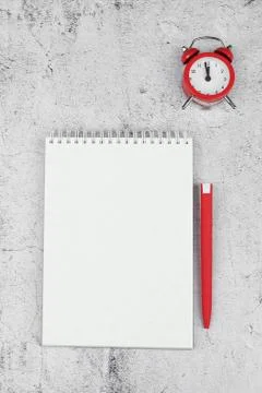 Time management concept. To-do list: red alarm clock, pencil and notebook Foto stock