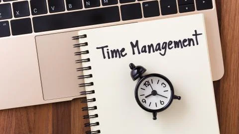 Time management concept with notebook and clock from top view Stock Photos