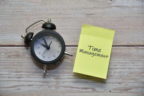 TIME MANAGEMENT text on sticky note with analog alarm clock. Business concept Foto stock