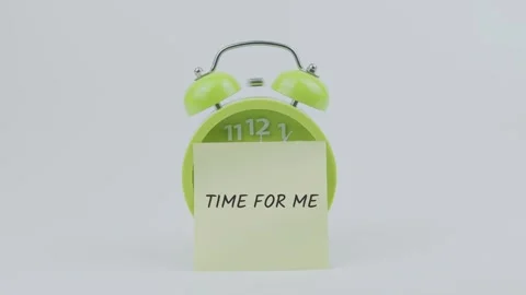 Time for me word on sticky note in front of green clock and ringing on white Stock Footage 313915289