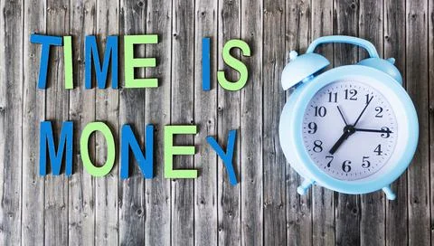 Time is money, the text is composed of multi-colored letters, next to an alar Stock Photos