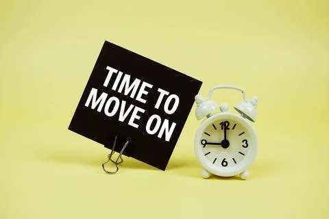 Time To Move On text message on paper card with alarm clcok on yellow backg.. 库存照片