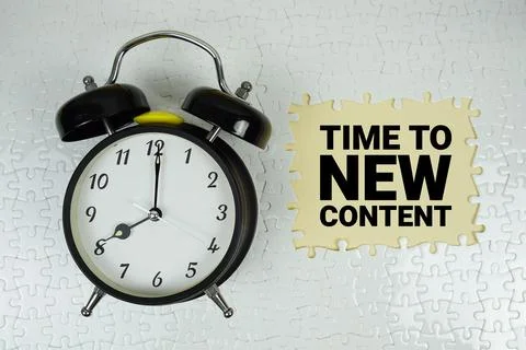 Time For New Content text with alarm clock on yellow background Stock Photos