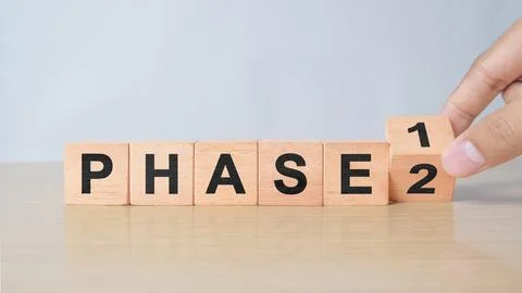 Time for Phase 2. Hand is turning a cube and changes the word 'Phase 1' to .. Stock Photos