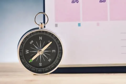 Time Planning and direction concept,  compas and calendar on wooden desk over Foto stock