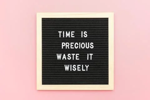 Time is precious waste it wisely. Motivational quote on letterboard on pink b Stock Photos