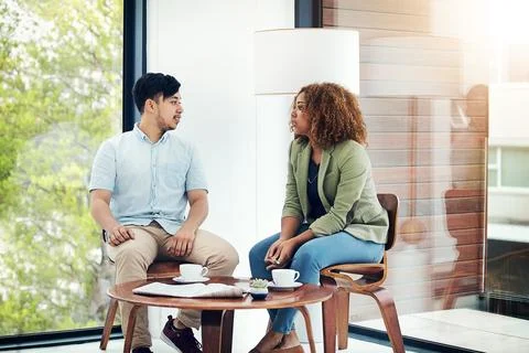 Time for a progress report. two creative colleagues sharing ideas in their Stock Photos