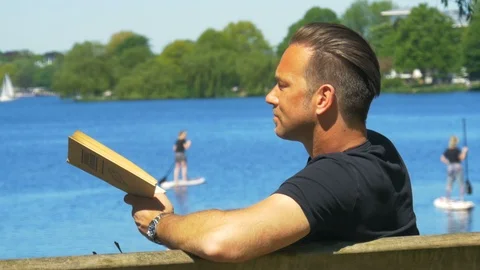 Time for Reflection - Book reading in a park Stock Footage 89564242