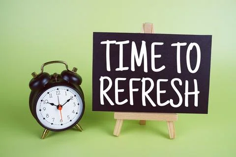 Time To Refresh text with easel and alarm clock on green background Stock Photos