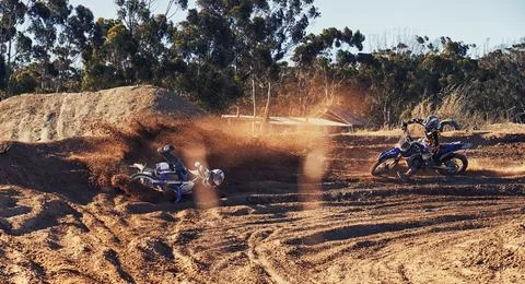 Time to rip up this track. a motocross rider baling as his competitor comes up Stock Photos
