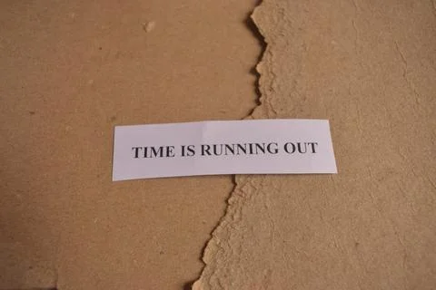 Time Is Running Out paper note on torn brown craft paper background Stock Photos