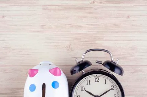 Time for saving money concept, flat lay image of alarm clock and piggy bank   Stock Photos