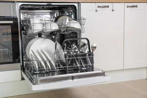 Time-saving technology. Open built-in dishwasher. White kitchen with integrat Stock Photos