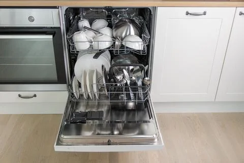 Time-saving technology. Open built-in dishwasher. White kitchen with integrat 스톡 사진