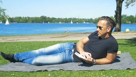 Time for self-reflection - a man relaxes on the weekend in the city park Stock Footage 89639861