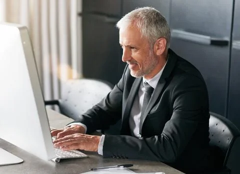 Time to sit and graph. a handsome mature businessman sitting down and working on Stock Photos
