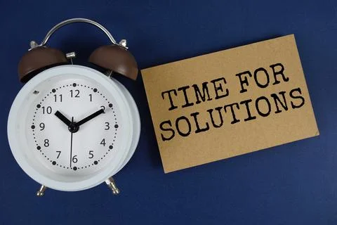 Time For Solutions text with alarm clock on blue background Stock Photos