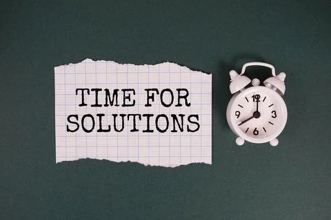 Time For Solutions text written on paper with alarm clock on green background Stock Photos