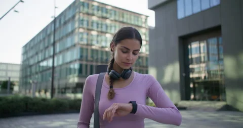 Time to start training. Calm pensive young woman in sportswear checks time on Stock Footage 160207018