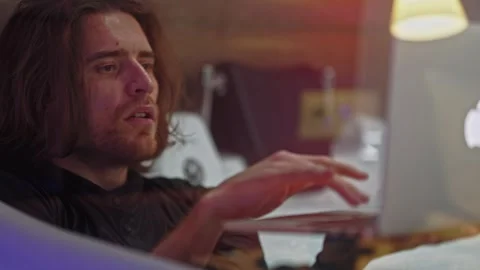 A time-starved man opens his work laptop while lying in the bathtub in his Stock Footage 252273942