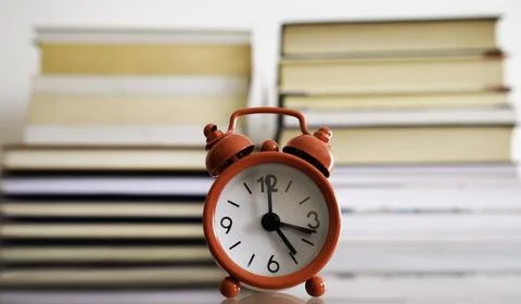 Time to study. Alarm clock in front of books. Foto stock