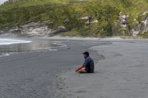 Time to think, a man sits watching the sea Stock Photos