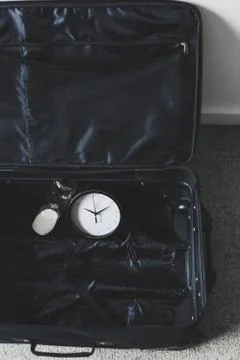Time to travel or delay during a trip,  empty suitcase with clock and hourgla Stock Photos