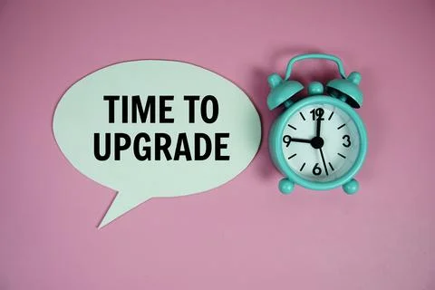 Time to upgrade text on speech bluble with alarm clock top view on pink bac.. Foto stock