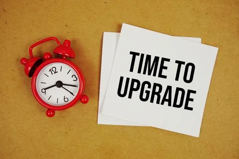 Time To Upgrade text on sticky note with alarm clock on paper craft backgroun 写真素材
