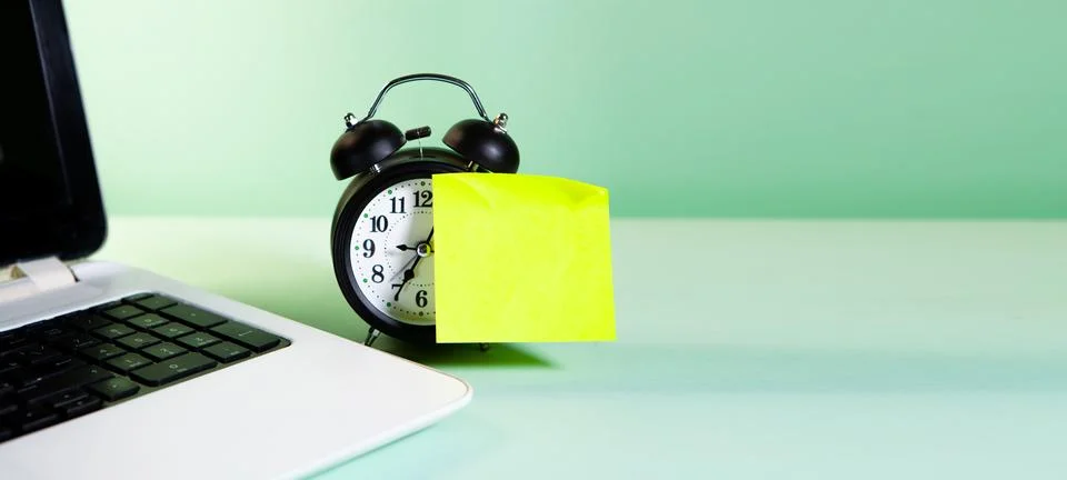 Time for a work. a alarm clock and a notebook on a yellow background. Foto stock