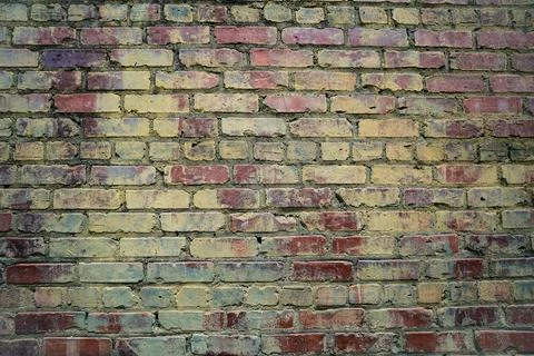 Time worn brick wall with hints of old paint in greens and blues Stock Photos
