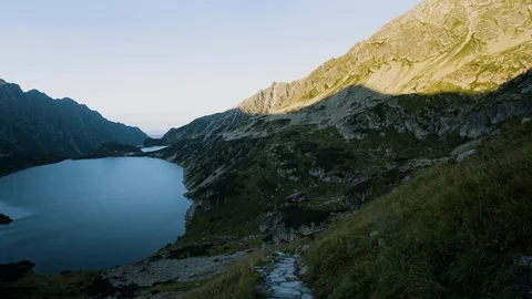 Timelaps of a lake hidden between mountain peaks 4k HDR H264 Stock Footage 88321345