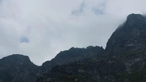 Timelaps of mountain peaks lit between the clouds 4k HDR H264 Stock Footage 88324791