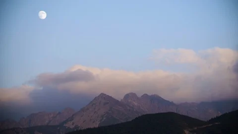 Timelaps of the mountains showing the passage of clouds and the moon in the sky  Stock Footage 88322130