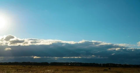 Timelaps of moving fluffy clouds in the evening sky during sunset  in  meadow Vídeos de archivo 91667418