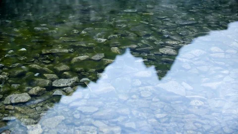 Timelaps of a stony bottom of the lake that changes into mountain peaks in the w Stock Footage 88320976