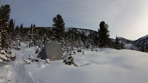 Timelaps tent in a snowy forest at sunset Stock Footage 84599276