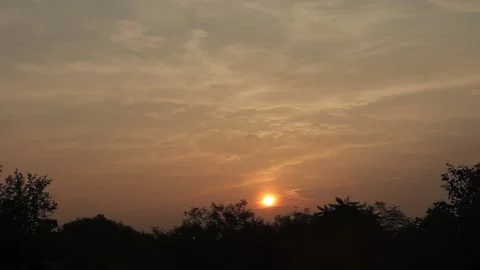 Timelaps video of the sun rising from behind the hills and trees in the early Stock Footage 162312851