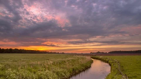 Timelapse 4K 30fps of Summer Sunrise over lowland river in flat countryside Stock Footage 76986541