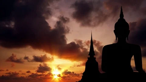 Timelapse abstract of silhouetted Buddha image, with drifting clouds Video stock 74962772