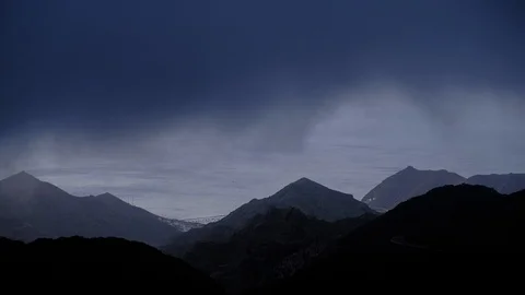 Timelapse aerial view of dramatic sunrise clouds running over mountains in An Stock Footage 120792401